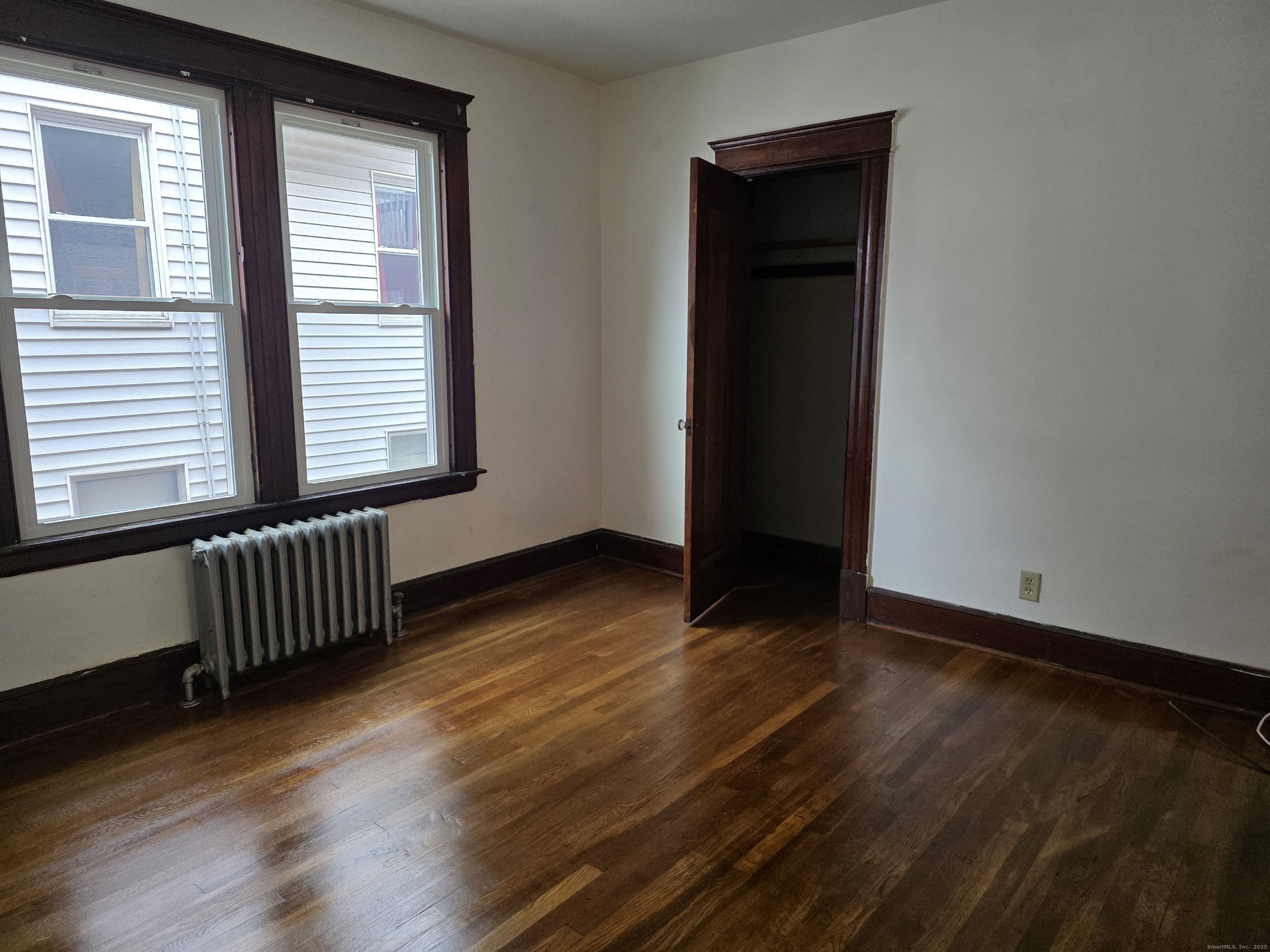 166 Oak Street, Unit 2 Waterbury, CT 06704 - Photo 7 of 13 a view of an empty room with wooden floor and a window