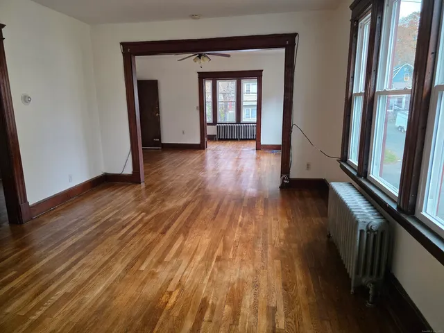 a view of a hallway with wooden floor and stairs