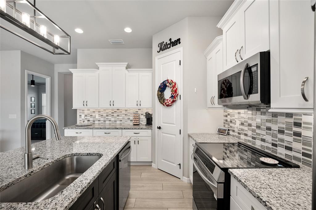 12092 Southwest 29th Place Gainesville, FL 32608 - Photo 11 of 38 a kitchen with stainless steel appliances granite countertop a sink stove and refrigerator