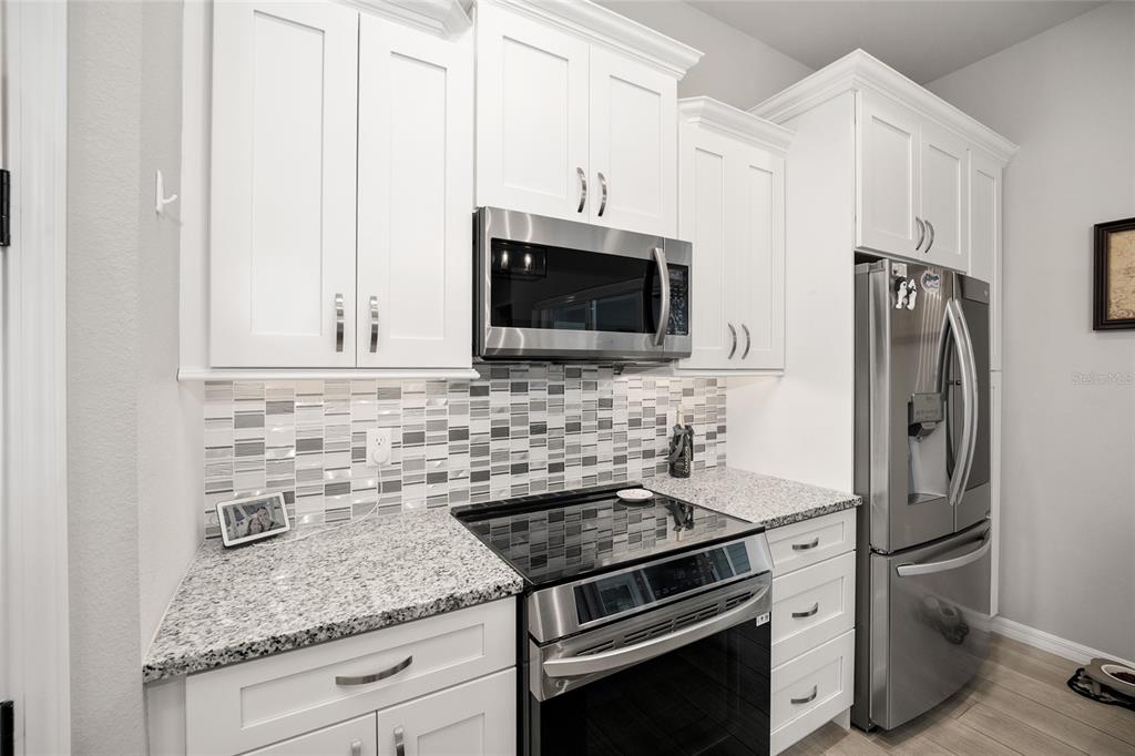 12092 Southwest 29th Place Gainesville, FL 32608 - Photo 12 of 38 a kitchen with stainless steel appliances granite countertop a stove microwave and refrigerator