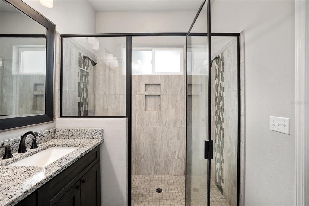 12092 Southwest 29th Place Gainesville, FL 32608 - Photo 15 of 38 a bathroom with a granite countertop sink mirror and shower