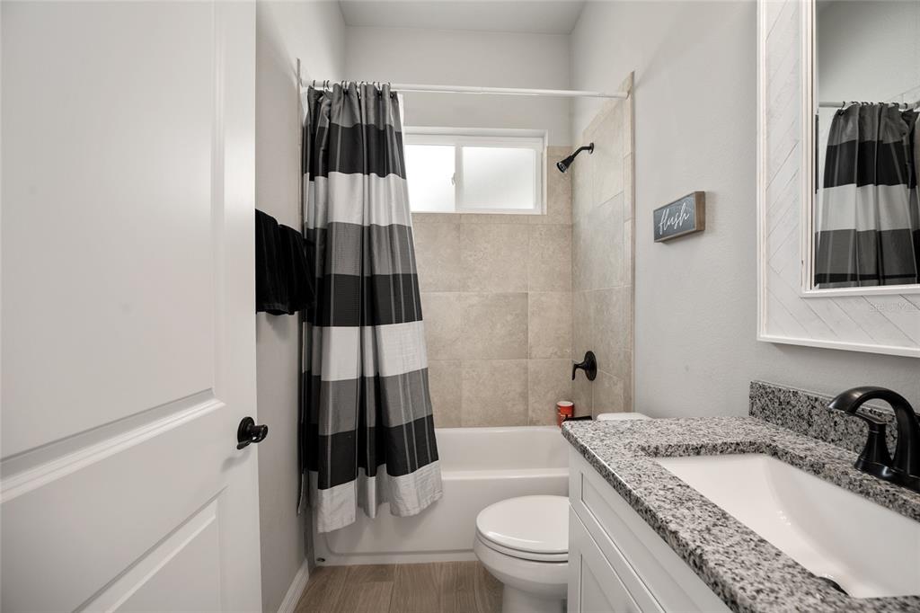 12092 Southwest 29th Place Gainesville, FL 32608 - Photo 18 of 38 a bathroom with a granite countertop sink toilet and shower