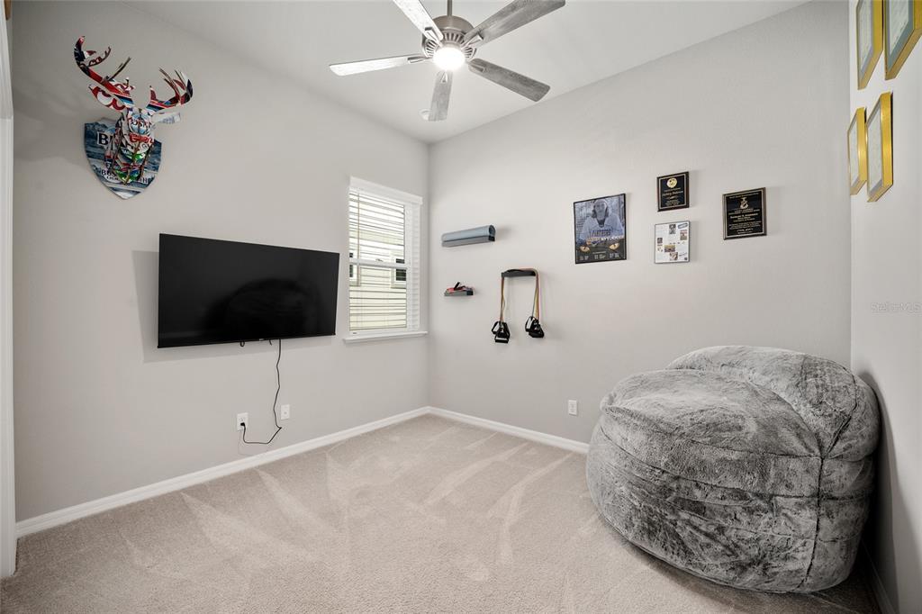 12092 Southwest 29th Place Gainesville, FL 32608 - Photo 19 of 38 a bedroom with a bed and a flat screen tv