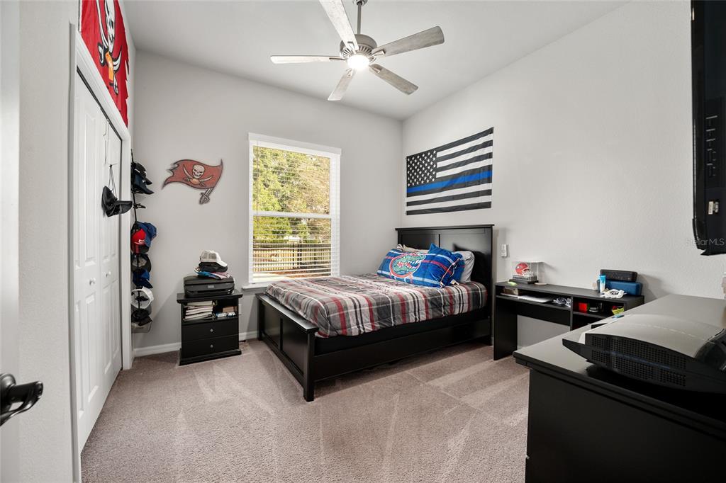 12092 Southwest 29th Place Gainesville, FL 32608 - Photo 21 of 38 a bedroom with a bed and a chandelier