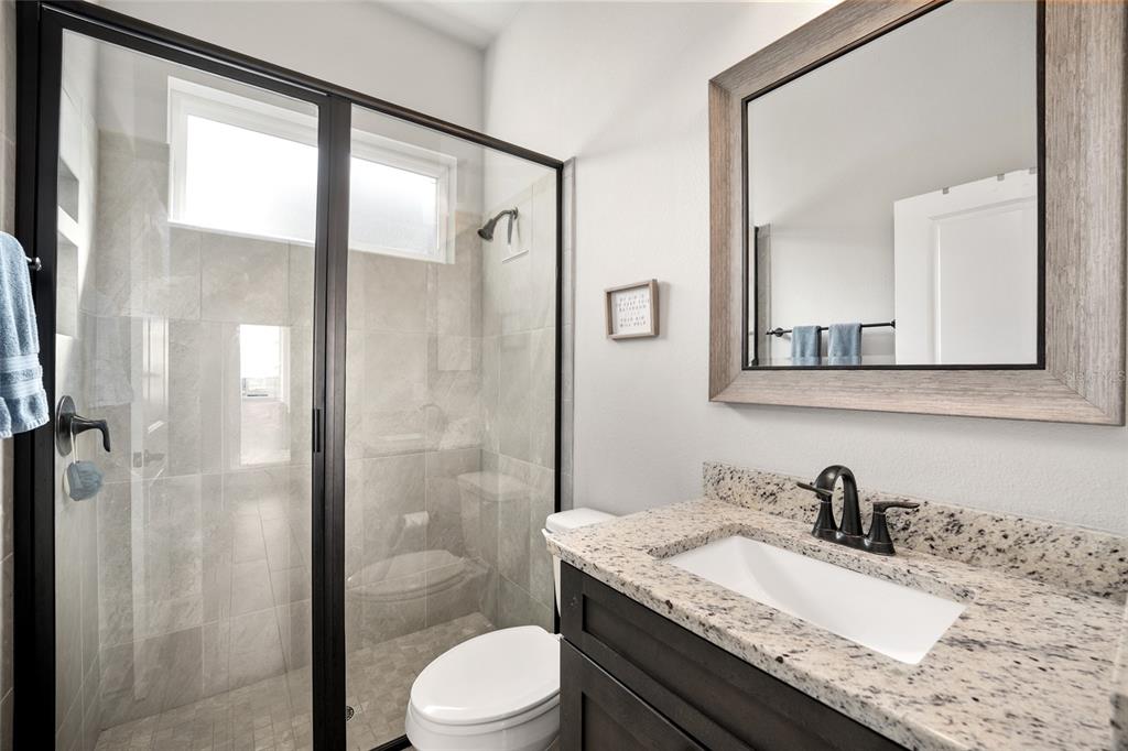 12092 Southwest 29th Place Gainesville, FL 32608 - Photo 22 of 38 a bathroom with a granite countertop sink toilet and shower
