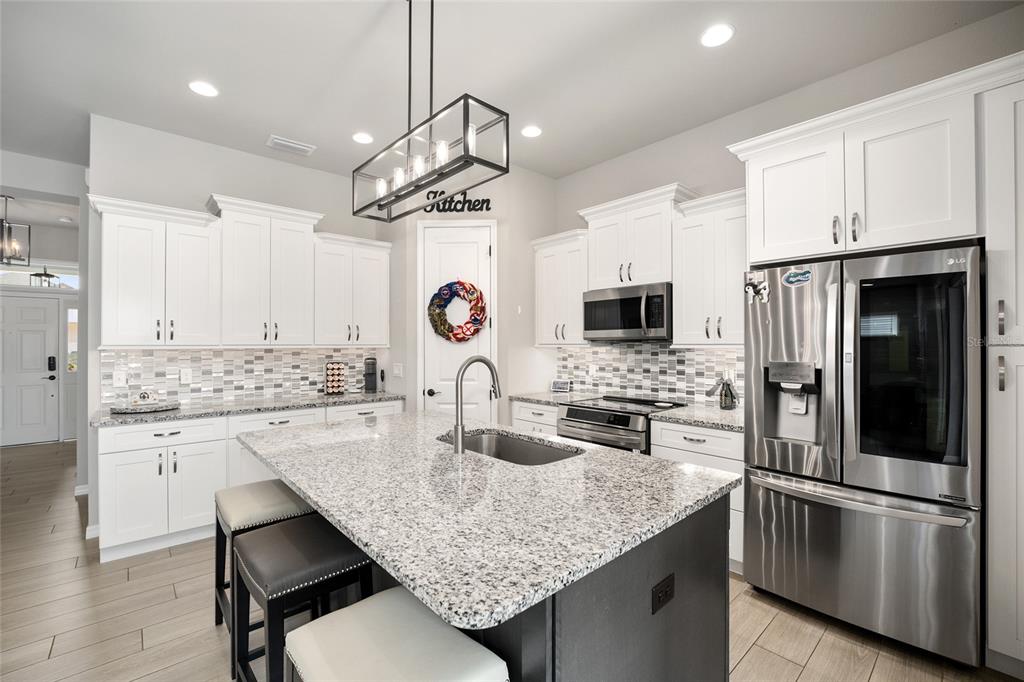 12092 Southwest 29th Place Gainesville, FL 32608 - Photo 10 of 38 a kitchen with stainless steel appliances granite countertop a sink refrigerator stove microwave and cabinets