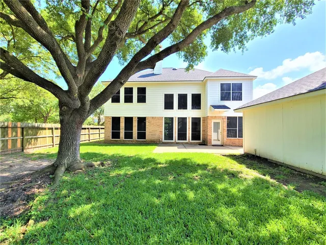 a house that has a big yard with large trees