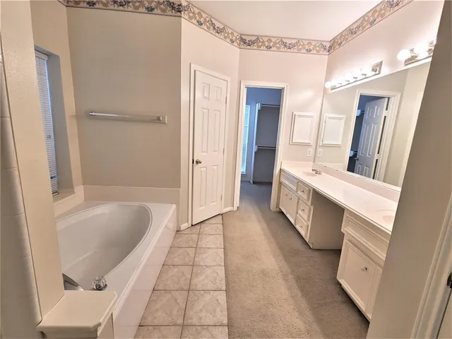 a bathroom with a tub sink and mirror