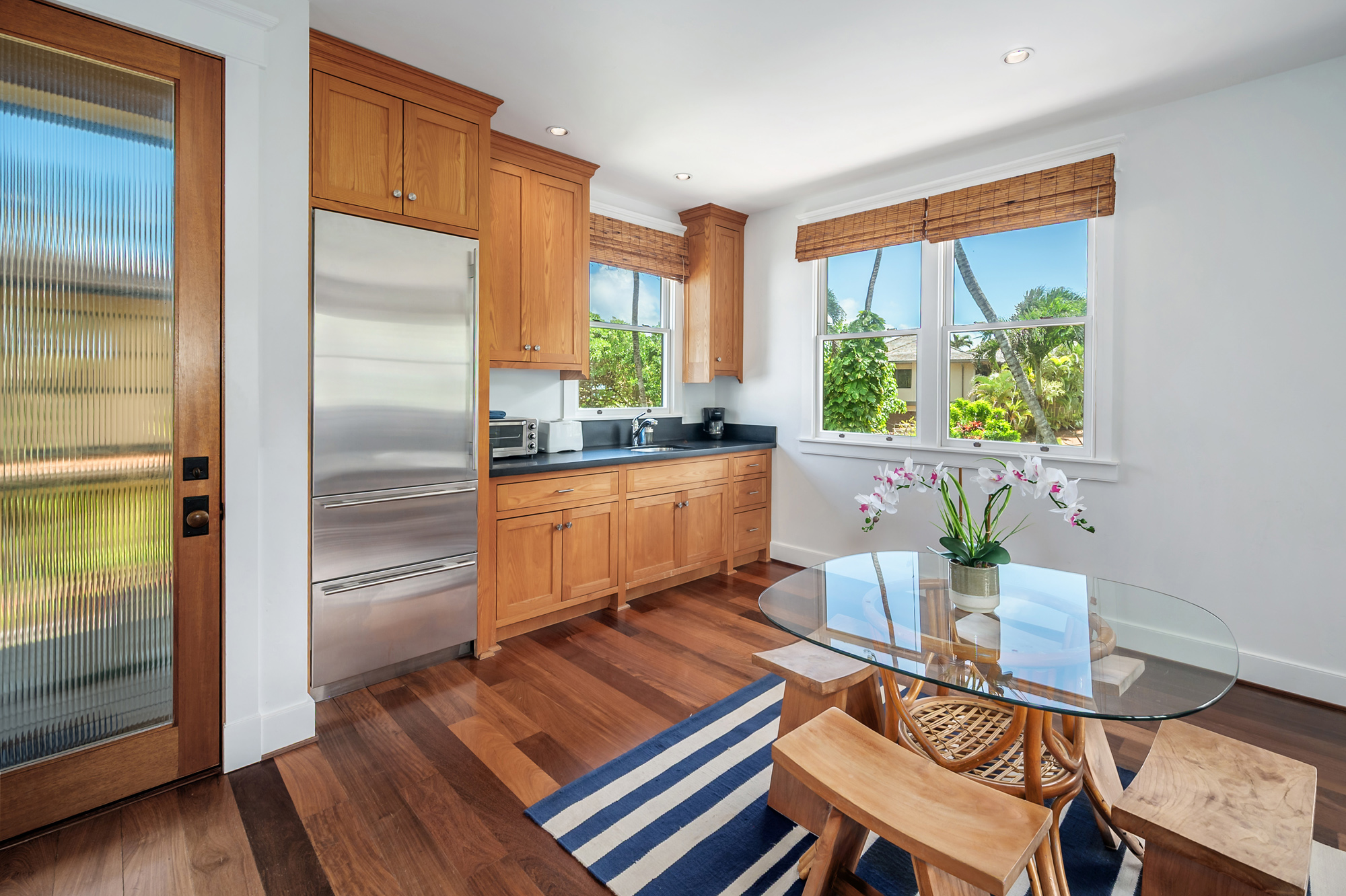 5070 Kukuna Road Kilauea, HI 96754 - Photo 21 of 29 a living room with a table chairs and a refrigerator