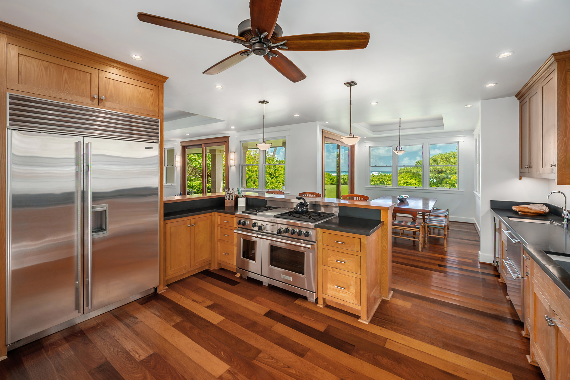 5070 Kukuna Road Kilauea, HI 96754 - Photo 9 of 29 a kitchen with stainless steel appliances a stove a refrigerator and a view of living room