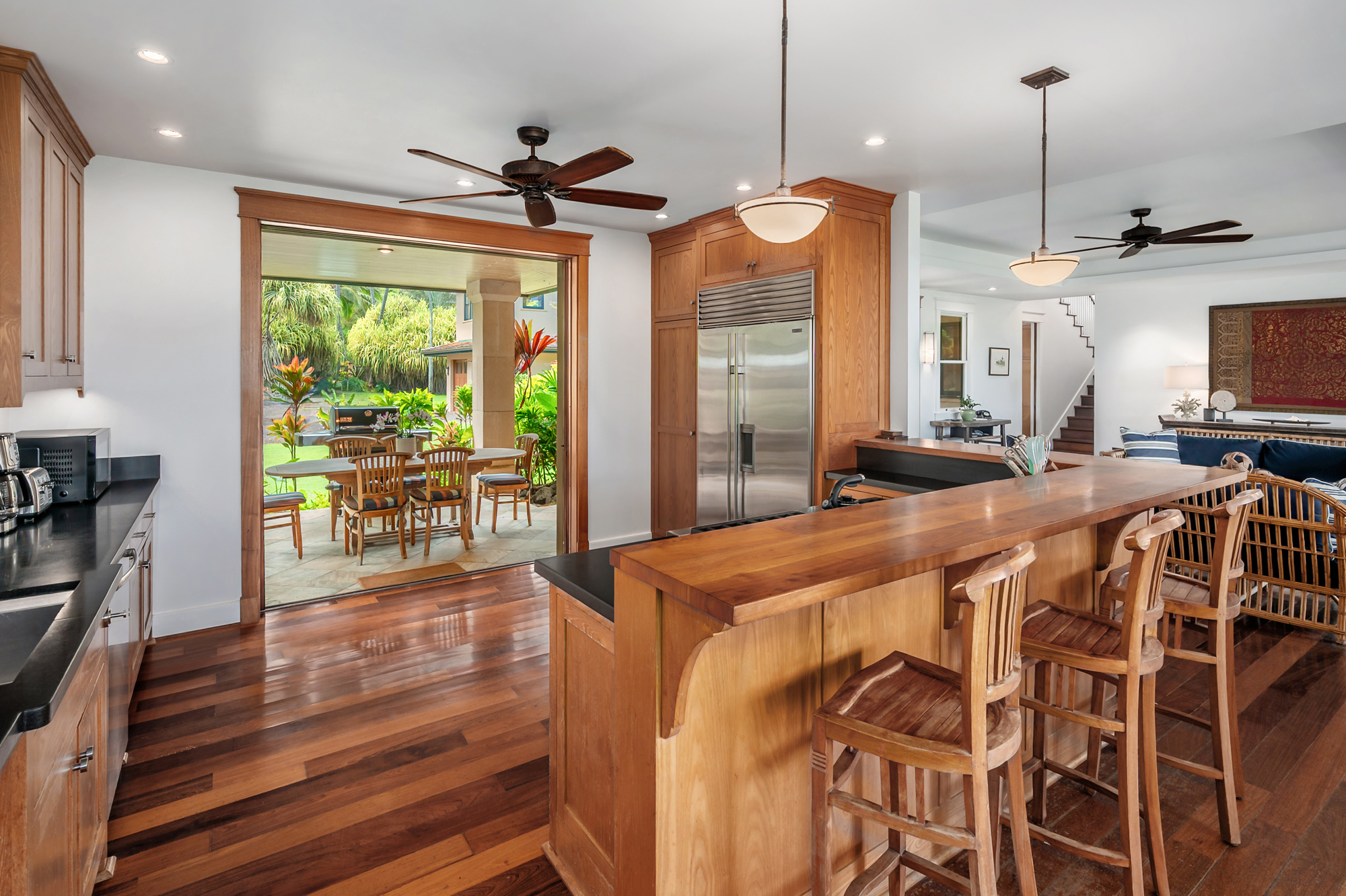 5070 Kukuna Road Kilauea, HI 96754 - Photo 10 of 29 a room with kitchen island a large window and a chandelier