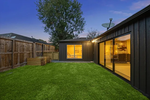 a view of a house with a yard and wooden fence