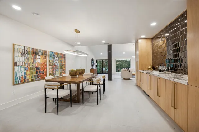 a open dining room with stainless steel appliances kitchen island granite countertop a sink and a refrigerator