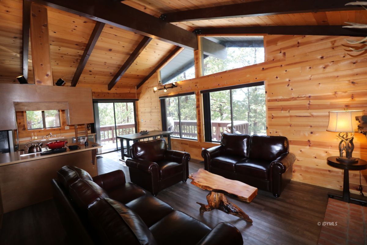 24796 Fern Valley Road Idyllwild, CA 92549 - Photo 7 of 20 a living room with furniture floor to ceiling windows and wooden floor