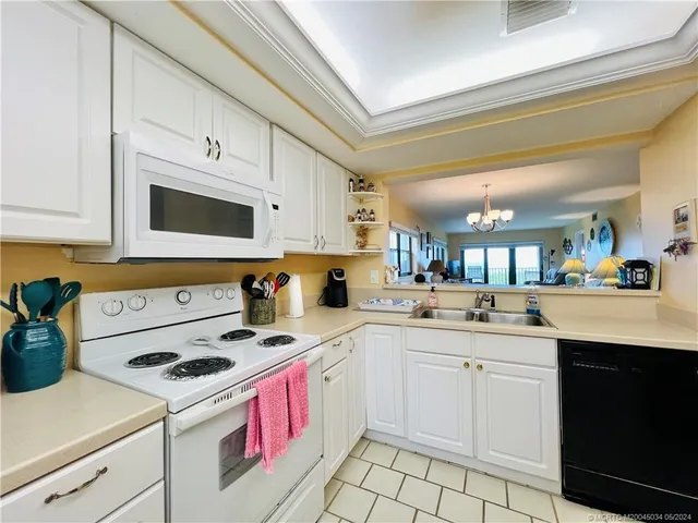 a kitchen with kitchen island a sink a stove and cabinets