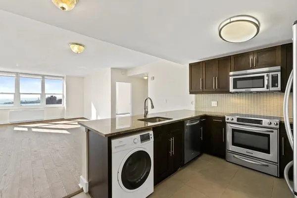 a kitchen with stainless steel appliances granite countertop a refrigerator sink and stove