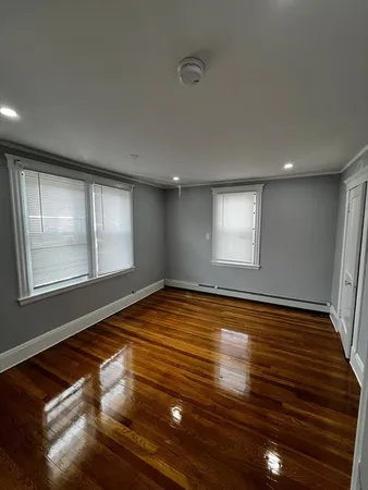 a view of empty room with window and wooden floor
