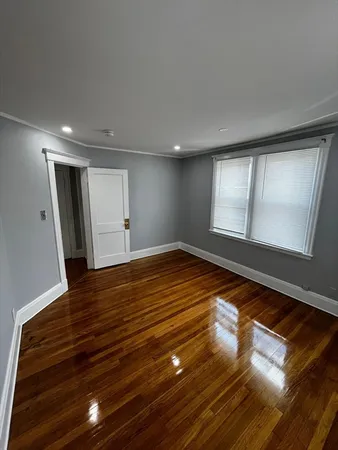 a view of empty room with window and wooden floor