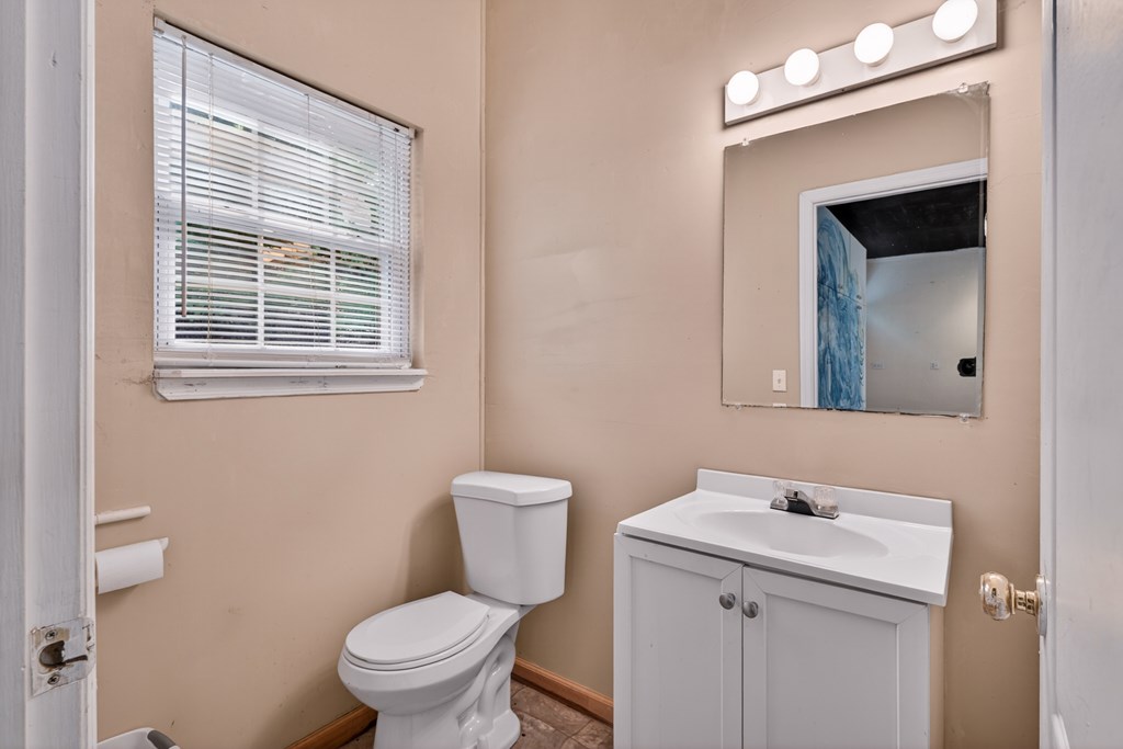 282 West Cherry Road Hayesville, NC 28904 - Photo 31 of 45 a bathroom with a toilet a sink a mirror and a window