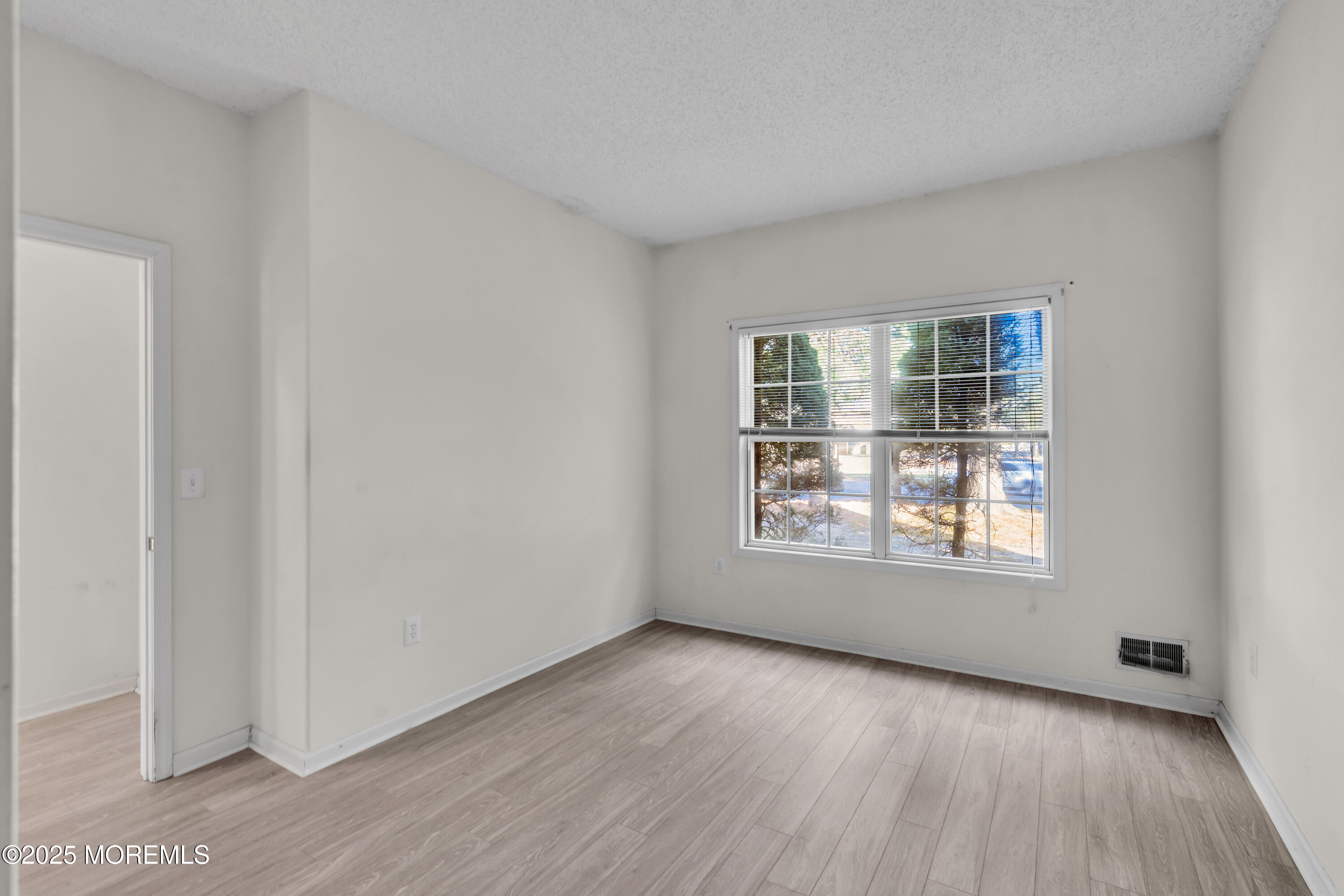 32 Riva Boulevard, Unit 2277 Brick, NJ 08723 - Photo 19 of 23 an empty room with wooden floor and windows