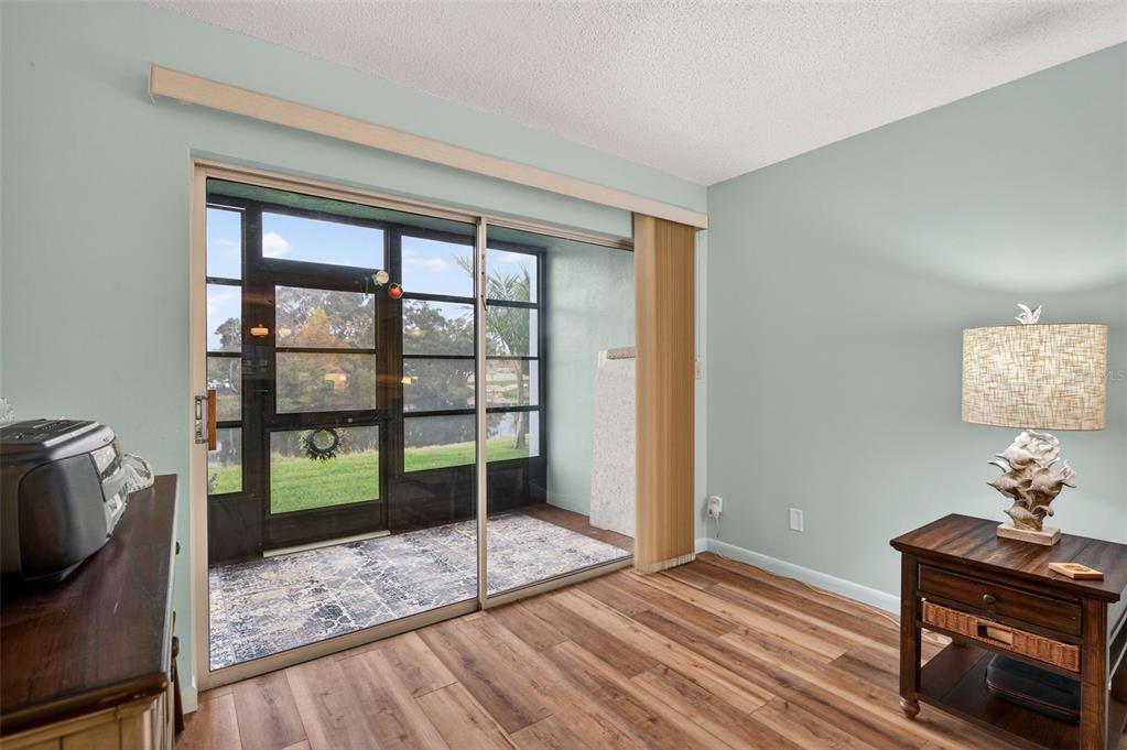1430 Heather Ridge Boulevard, Unit 101 Dunedin, FL 34698 - Photo 12 of 44 a view of a livingroom with wooden floor and a window