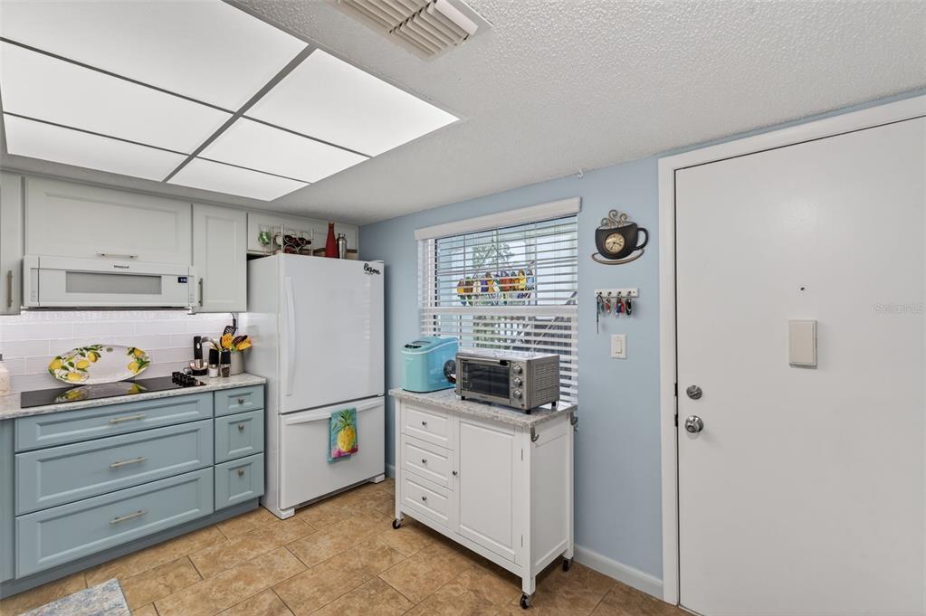 1430 Heather Ridge Boulevard, Unit 101 Dunedin, FL 34698 - Photo 14 of 44 a kitchen with refrigerator and cabinets