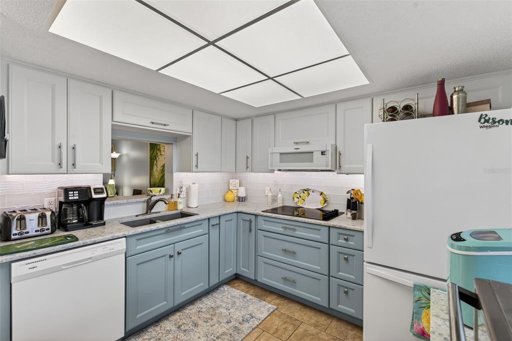 1430 Heather Ridge Boulevard, Unit 101 Dunedin, FL 34698 - Photo 15 of 44 a kitchen with a sink a stove and cabinets