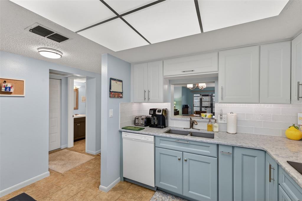 1430 Heather Ridge Boulevard, Unit 101 Dunedin, FL 34698 - Photo 16 of 44 a kitchen with stainless steel appliances granite countertop a sink and cabinets