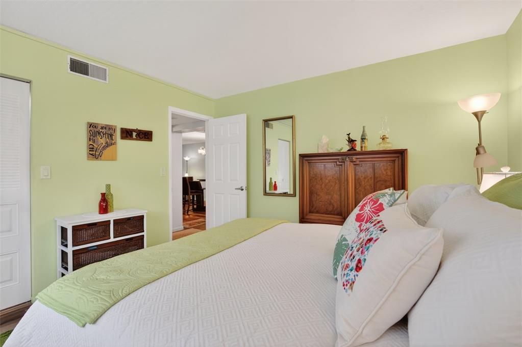 1430 Heather Ridge Boulevard, Unit 101 Dunedin, FL 34698 - Photo 22 of 44 a bedroom with a bed and wooden floor