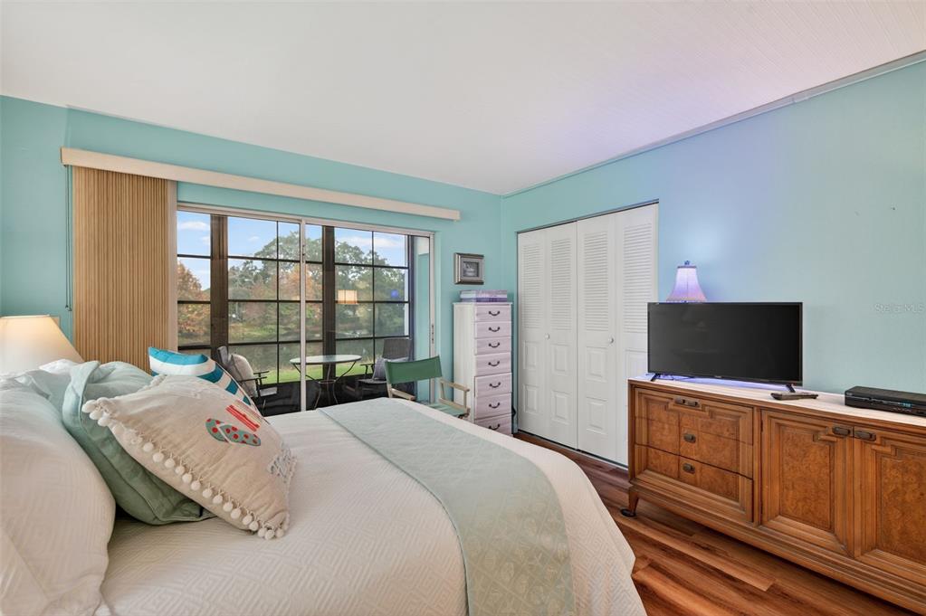 1430 Heather Ridge Boulevard, Unit 101 Dunedin, FL 34698 - Photo 26 of 44 a bedroom with a bed and a flat screen tv