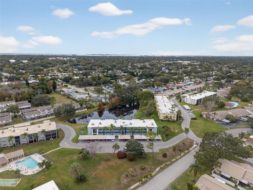 1430 Heather Ridge Boulevard, Unit 101 Dunedin, FL 34698 - Photo 39 of 44 an aerial view of a city with lots of residential buildings ocean and mountain view in back
