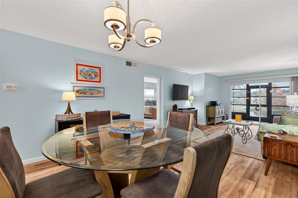 1430 Heather Ridge Boulevard, Unit 101 Dunedin, FL 34698 - Photo 5 of 44 a dining room with furniture a rug and wooden floor