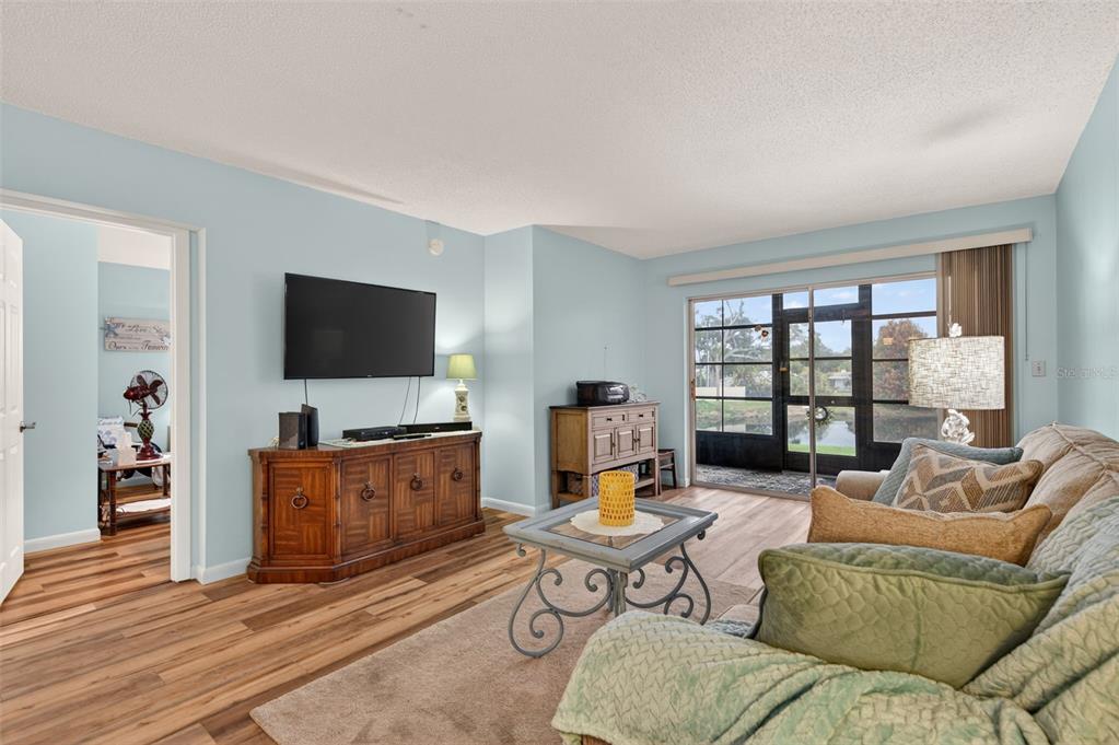 1430 Heather Ridge Boulevard, Unit 101 Dunedin, FL 34698 - Photo 7 of 44 a living room with furniture and a flat screen tv
