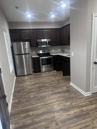 a kitchen with stainless steel appliances granite countertop a refrigerator and a stove top oven