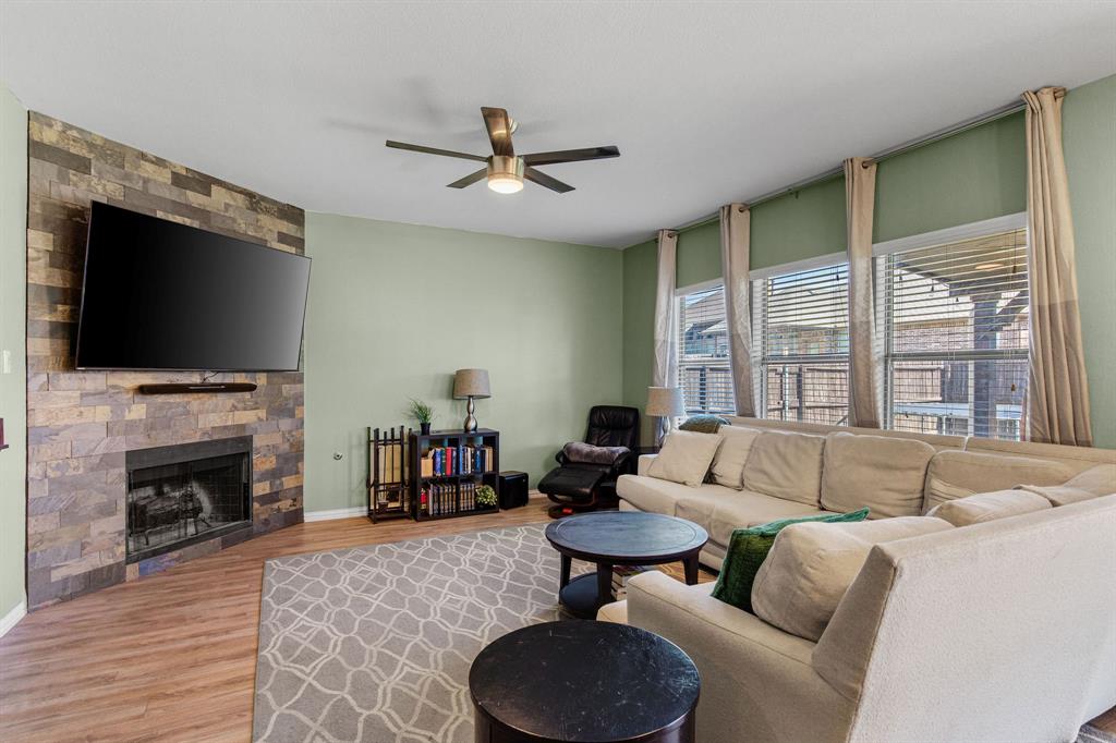 3213 Evening Wind Road Denton, TX 76208 - Photo 8 of 28 a living room with furniture a fireplace and a flat screen tv