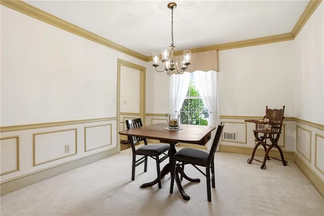 a view of a dining room with furniture and a chandelier