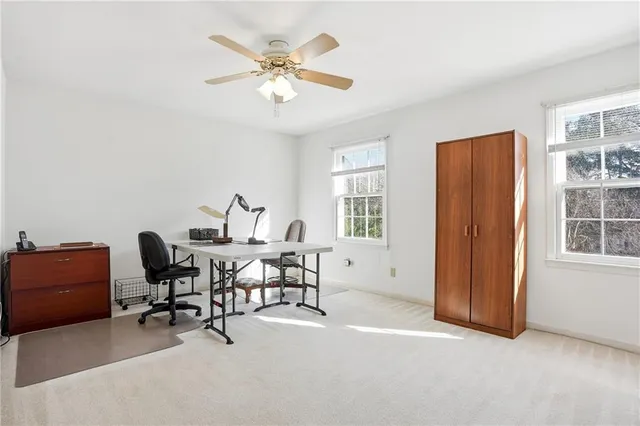 a view of a workspace with furniture and a window