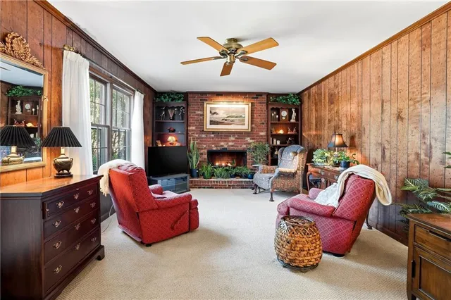 a living room with furniture a fireplace and a large window