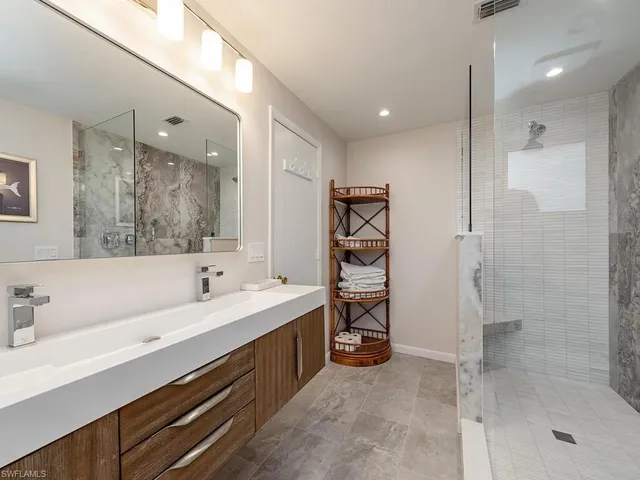 a bathroom with a double vanity sink mirror and shower