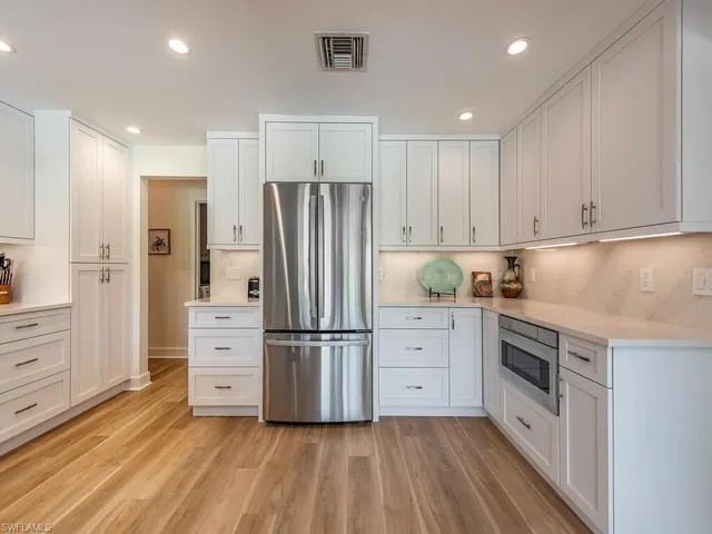 a kitchen with white cabinets and stainless steel appliances