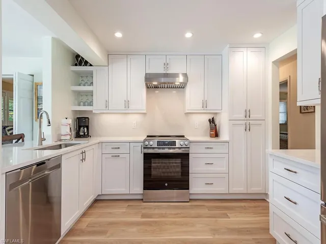 a kitchen with stainless steel appliances granite countertop a stove and a sink