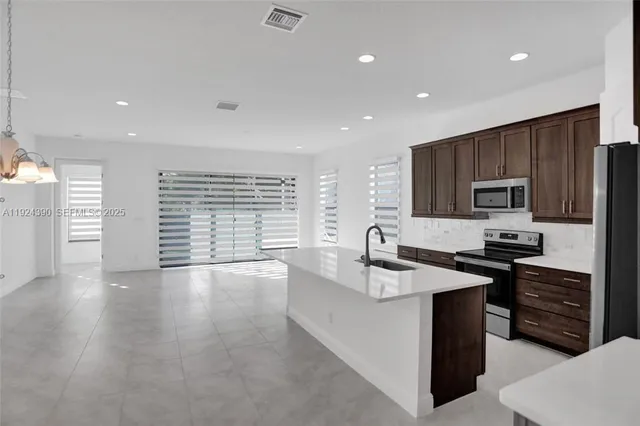 a kitchen with granite countertop a stove sink and cabinets