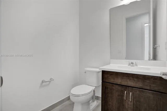 a bathroom with a granite countertop sink a toilet and a mirror