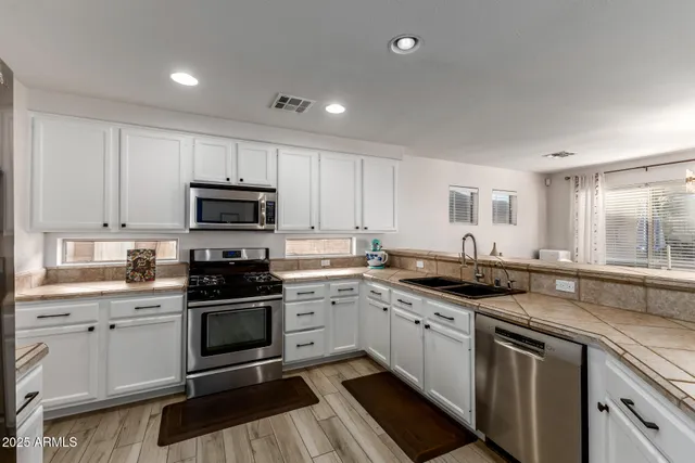 a kitchen with a sink stove cabinets and window