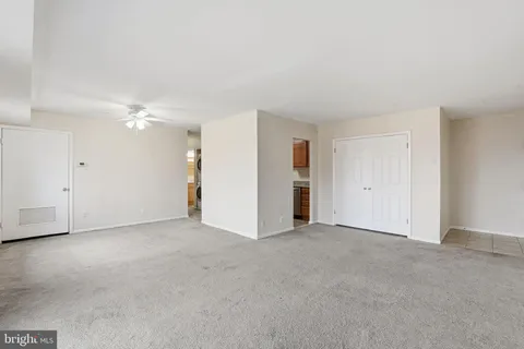 an empty room with an entryway and closet area