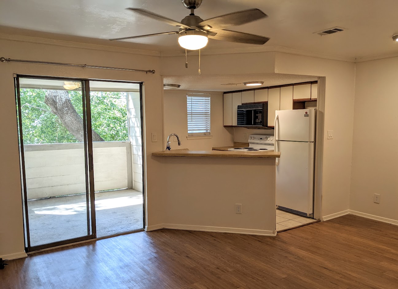 2500 Burleson Road, Unit 615 Austin, TX 78741 - Photo 5 of 13 a kitchen with kitchen island wooden floor and a refrigerator