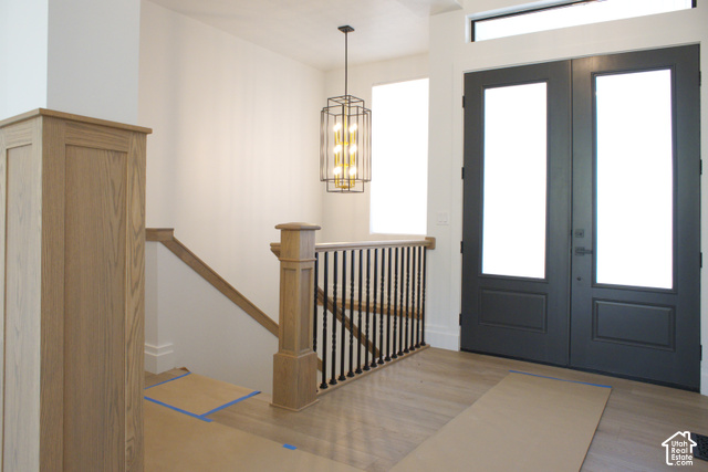 3504 North Sun Dancer Loop Logan, UT 84341 - Photo 26 of 59 Light wood-finish flooring, dual entry doors, transom window, contemporary chandelier, and wood staircase with iron balusters