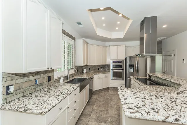a bathroom with a granite countertop sink a mirror and shower