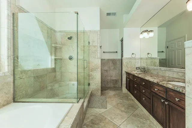 a bathroom with a granite countertop sink a mirror and a shower