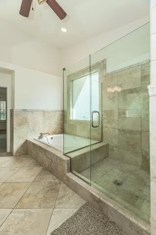 an empty room with a window and a chandelier fan